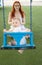 A little funny boy on swings on an outside playground with his ginger mother - looking in the camera