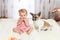 Little funny Caucasian girl the child sits at home on the floor on a light carpet with the best friend of the half-breed dog with