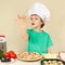 Little funny chef expressive enjoys cooked pizza