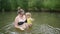 Little funny cute blonde girl child toddler in yellow bodysuit laughing learns swim outside at summer lake. Plus size