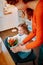 Little funny daughter watering home flowers with mother