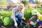 Little gardener girl with mother watering on lawn near house