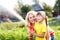 Little gardener girl with mother watering on lawn near house