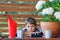 Little gardener near plants pots in balcony, terrace in backyard.