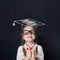 Little genius kid in graduation hat with thumb up