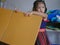 Little girl, 3 years old, moving a cardboard box, preparing to build something by herself, at home