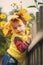 Little girl 3 years old in a yellow vest and wreath of yellow autumn leaves on her head looks away. Child portrait in fall. Close