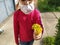 Little girl 6 years old in a pink sweater and a white surgical protective mask. The child holds in his hands a bouquet of yellow