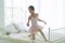 Little girl 9 year dancing ballet with white bed in bedroom at home, Ballerina young girl practicing ballet