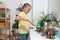 Little girl adding soil into peat pots on window sill indoors. Growing vegetable seeds