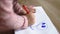 Little girl adorably drawing on paper with a red pencil
