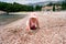 Little girl is on all fours on the beach by the water against the backdrop of the Milocer villa