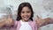 Little girl alone isolated on painted wall showing thumbs up joyful