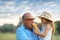 A little girl in the arms of her grandfather in a blue shirt, feeds him with bread. Joy and childhood. Baking, pies, bread. Family