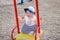 Little girl baby in a cap plays with toys in a sandbox with sand on the playground