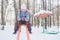 Little girl balancing on winter playground seesaw