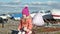 Little girl with a balloon sits on a river port travels