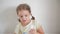 Little girl in bathroom putting a toothpaste on toothbrush