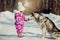 Little girl with beautiful big dog in the forest in winter time