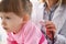 Little girl being examined by pediatrician female, calm child patiently waiting on appointment