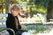 Little girl with Bible praying on bench outdoors