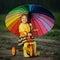 Little girl on the bicycle with umbrella