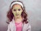 Little girl with big eyes and head and green facial mask