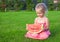 Little girl with big piece of watermelon in hands