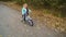 Little girl biking on four wheeled bicycle in park