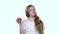 Little girl bites an apple and shows a thumbs up. White background. Slow motion