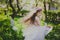 Little girl in black jacket and white dress dancing in the spring cherry garden