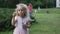 Little girl blow soap bubbles. Slow motion. Gimbal shot