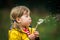 Little girl blowing on dandelion. Future generation. Windmills. Renewable energies and sustainable resources - wind