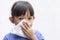 A little girl blowing her runny nose by tissue paper.