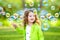 A little girl blowing soap bubbles