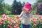 Little girl blowing soap bubbles in summer park and blooming tulips