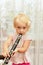 A little girl blows the clarinet and closes the chord switching holes with her fingers