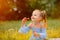 A little girl blows soap bubbles