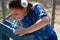 Little Girl in Blue Dress Using Drinking Fountain