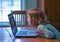 Little girl in blue and screen time on a lap top