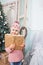 Little girl with book around the Christmas tree