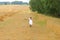 Little girl with a bouquet of wildflowers in her hands in a wheat field.