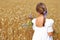 Little girl with a bouquet of wildflowers in her hands in a wheat field.