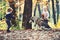 Little girl and boy friends play with husky pet in woods. Children training dog in autumn forest. Friendship and child