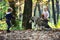 Little girl and boy friends play with husky pet in woods. Children training dog in autumn forest. Friendship and child