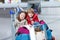 Little girl and boy sitting on suitcases on airport