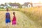 Little girl and boy standind on field with golden sunlight