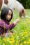 Little girl break yellow flowers