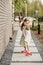 A little girl with a brush cleans a path on the street in the courtyard