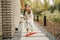 A little girl with a brush cleans a path on the street in the courtyard